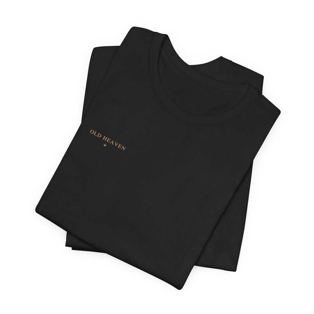 Folded black Old Heaven Cobalt Defiance T-shirt showing the small antique-gold wordmark and eight-point star.