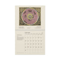 Mockup: the 2027 Cellarius wall calendar open at January, Cellarius’s plan of the Ptolemaic system above the January grid, on a white background
