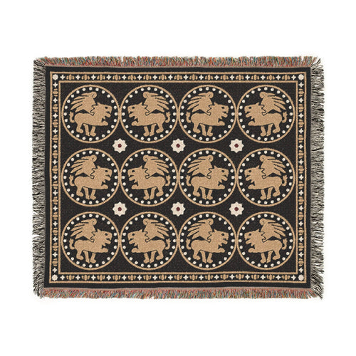The Golden Bestiary woven throw, 60 × 50 in, winged lions in gold roundels on charcoal