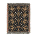 The Golden Bestiary woven throw, 54 × 70 in, winged lions and date palms in gold roundels on charcoal